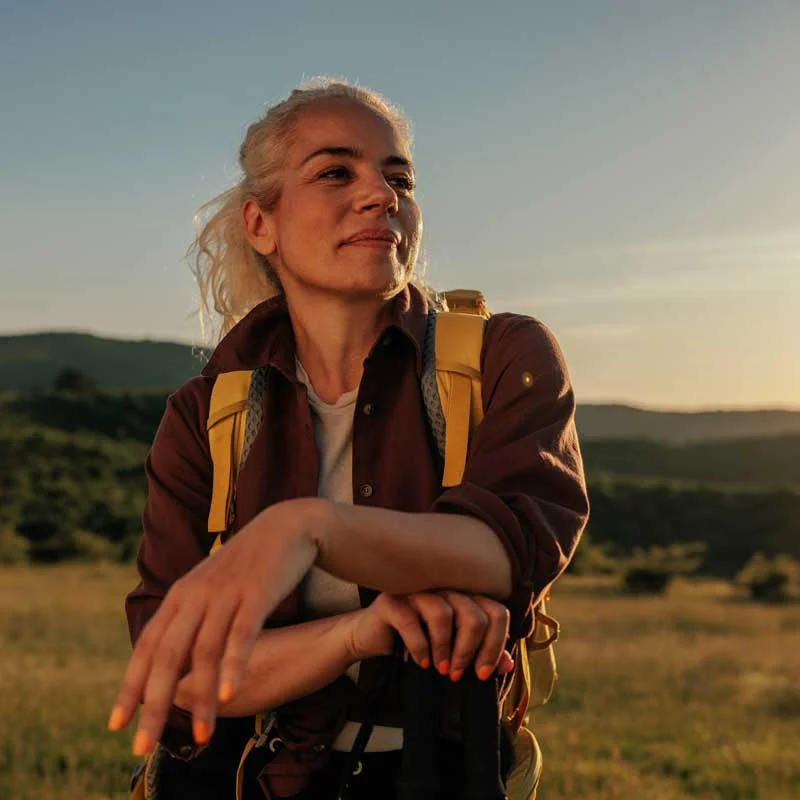 a woman takes a break from hiking to admire the view