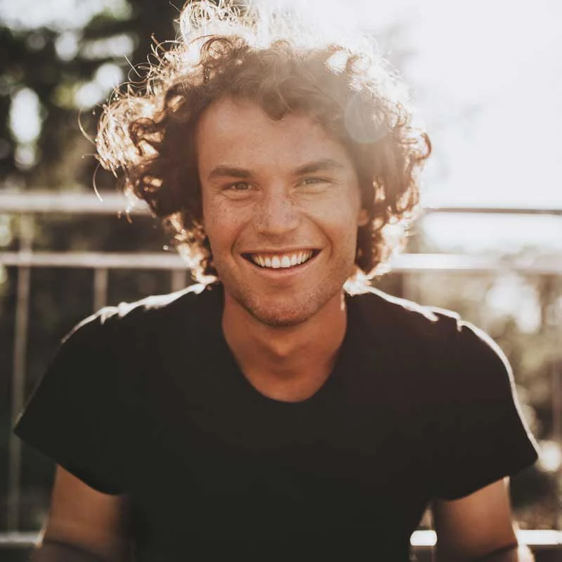 a young man smiles at the camera