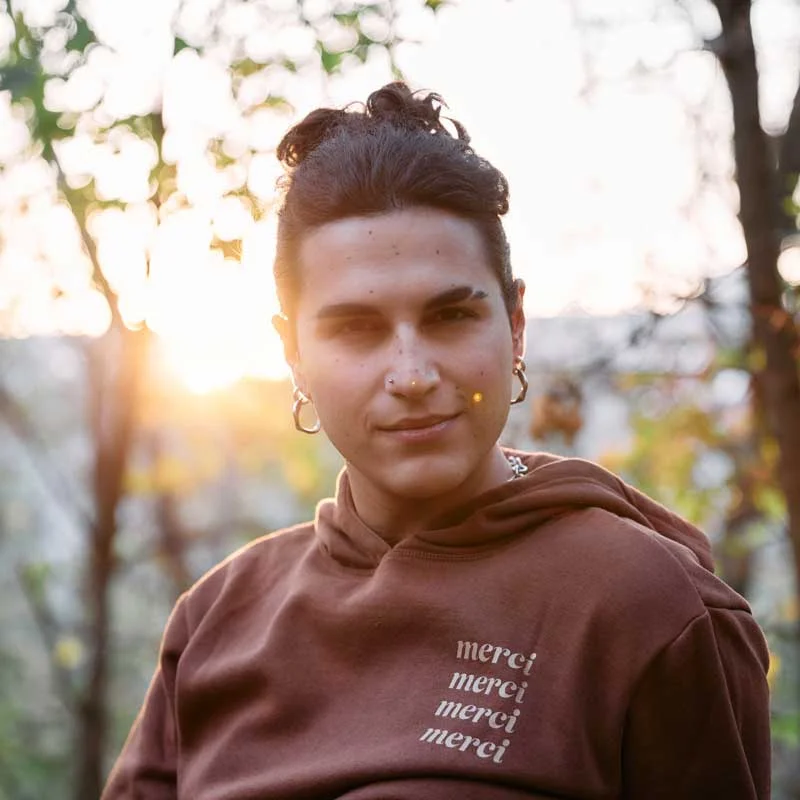 a young person with piercings looks at the camera