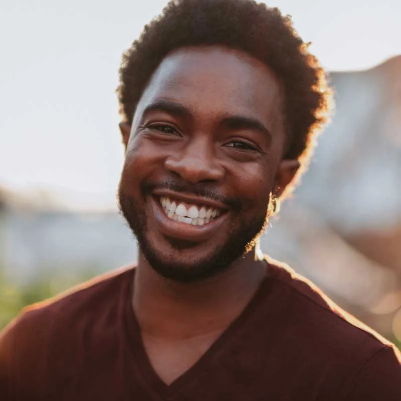 a young man smiles at the camera
