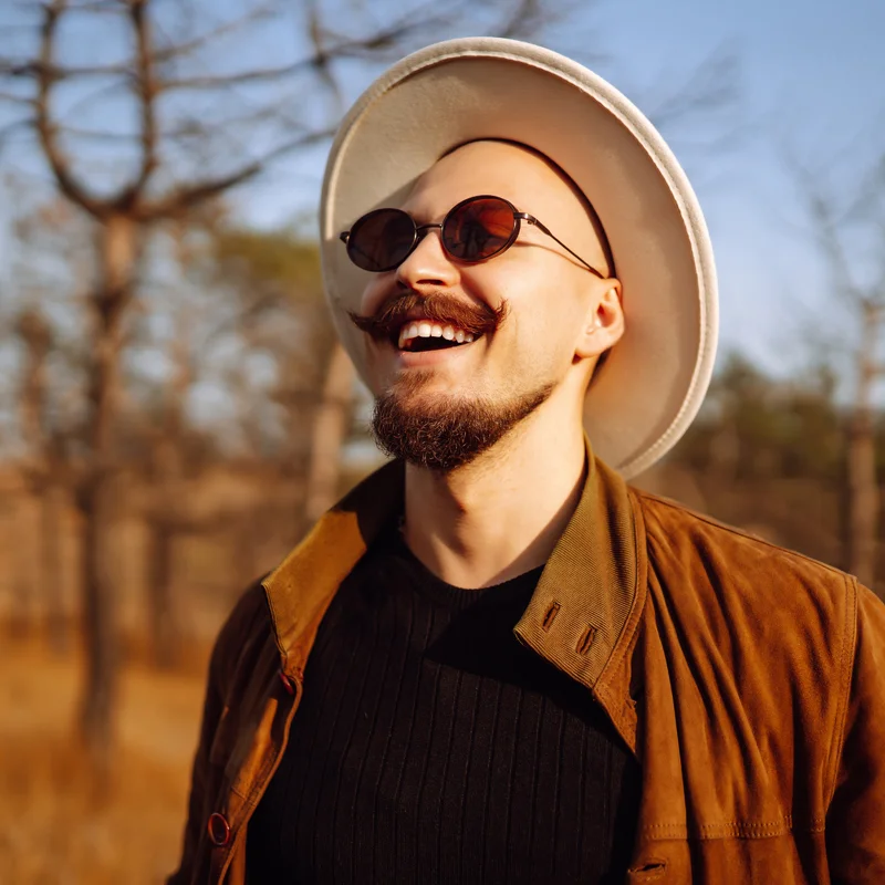 Man with hat and sunglasses smiling